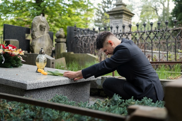 A hand burying a small tombstone with a feature name on it.