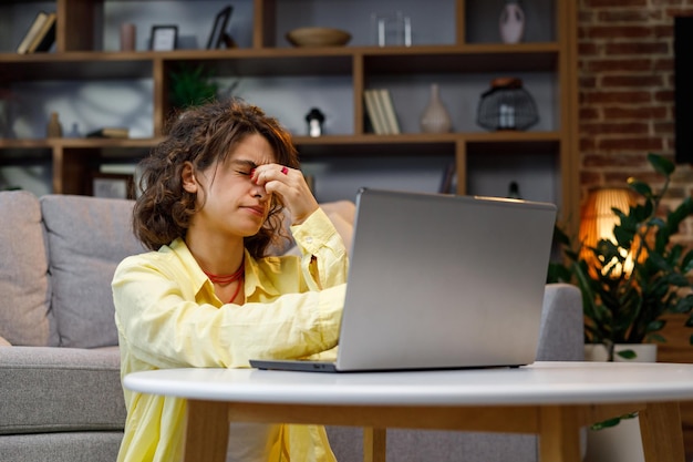 A person looking exhausted at a computer screen late at night
