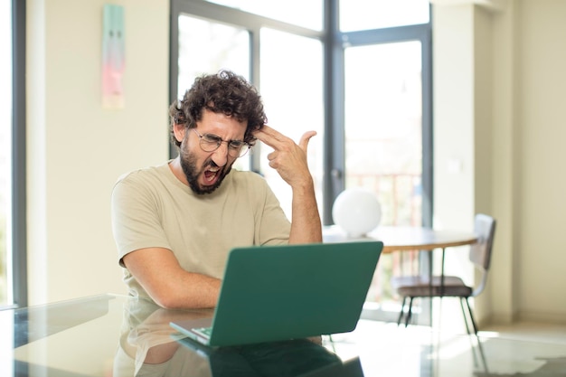 A person looking stressed while staring at a laptop screen with charts
