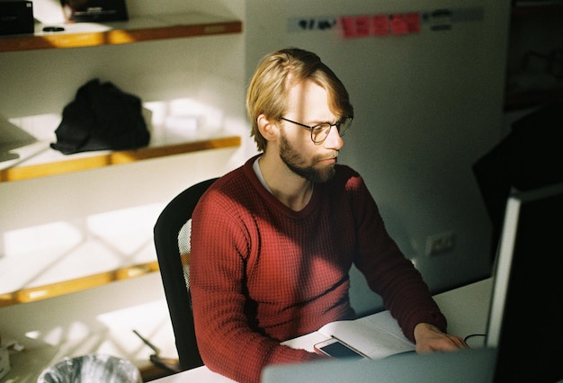 A person looking thoughtfully at a laptop screen with code on it.