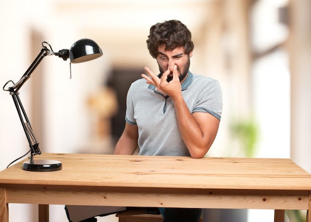 A person looking tired while sitting at a desk with a laptop open.