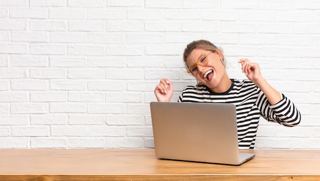 A person smiling while typing on a laptop, with a supportive community icon in the background.