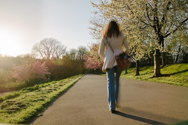 A person walking on a path in a park, looking relaxed.